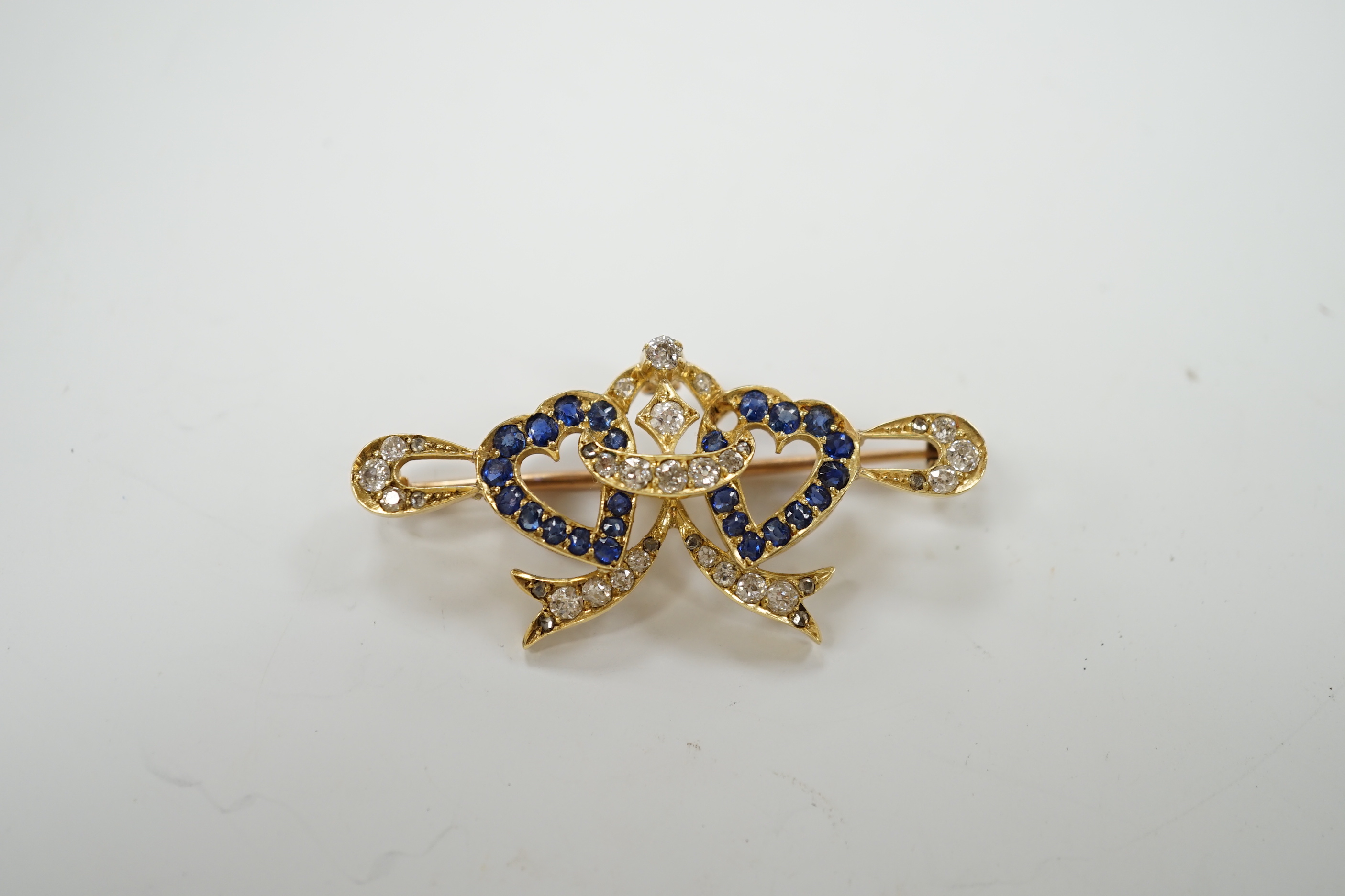 A yellow metal, sapphire and diamond set twin hearts bar brooch, 41mm, gross weight 4.8 grams.